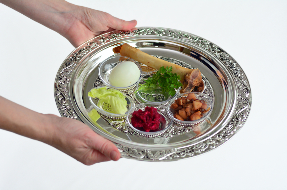 hand holds out seder plate