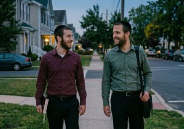 Two friends walking, demonstrating how a thoughtful Jewish greeting brings blessings upon he who gives it.