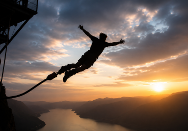 Silhouette of a person bungee jumping above a mountain valley at sunset, illustrating the theme of living life like a dream.