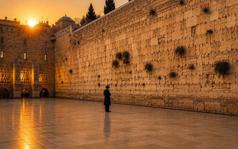 Person praying at the Kotel during the Three Weeks, expressing longing for the return of the Shechinah and greater K'vod Shamayim.